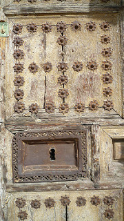 A beautiful old door, with a big old lock and a tiny little new lock.