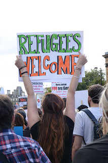 Woman in protest crowd holding up a sign that reads 