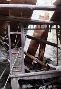 A marriage bed, ruined by a caved-in roof, in a forgotten building in Southern China.
